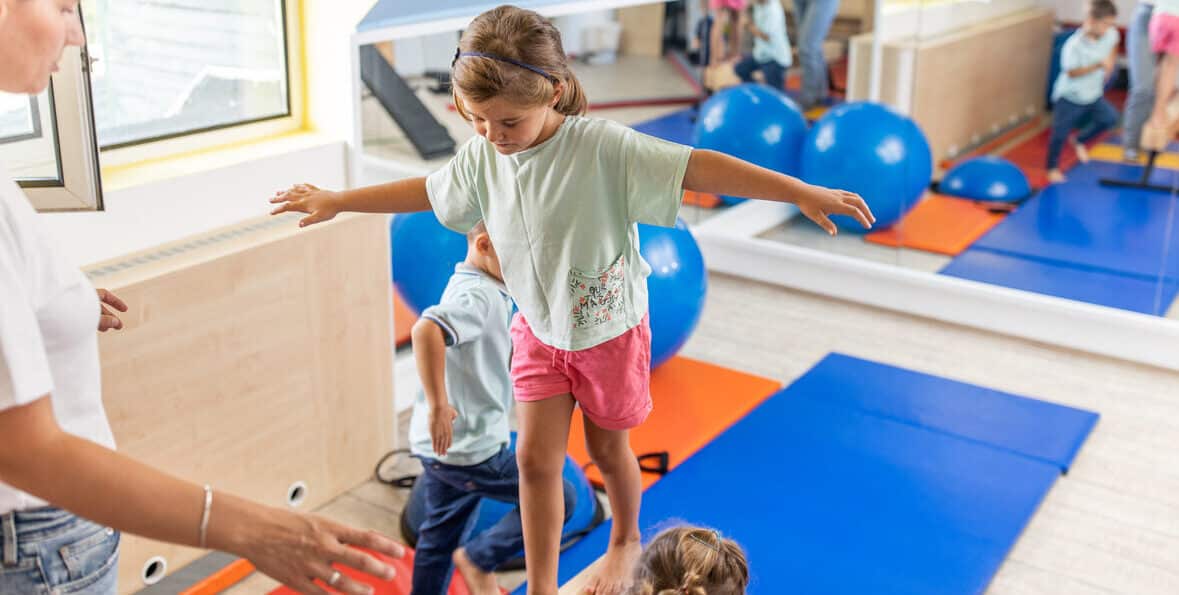 Multiple children working on their balance during a group pediatric physical therapy session