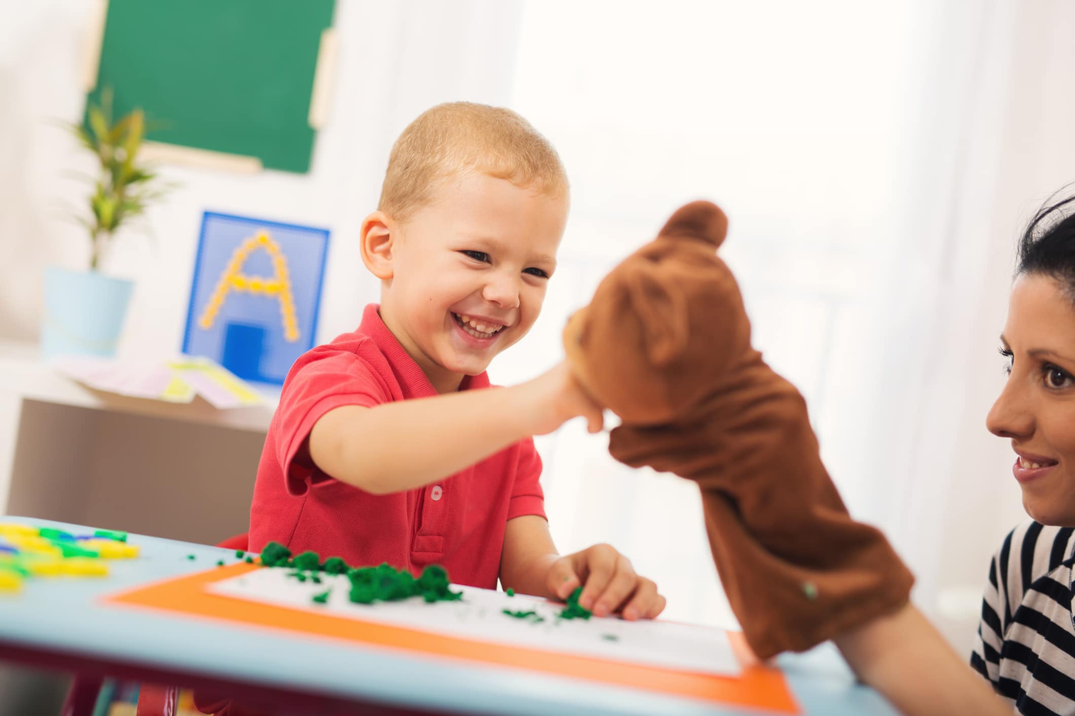 Speech therapist using a puppet to practice speech therapy lessons