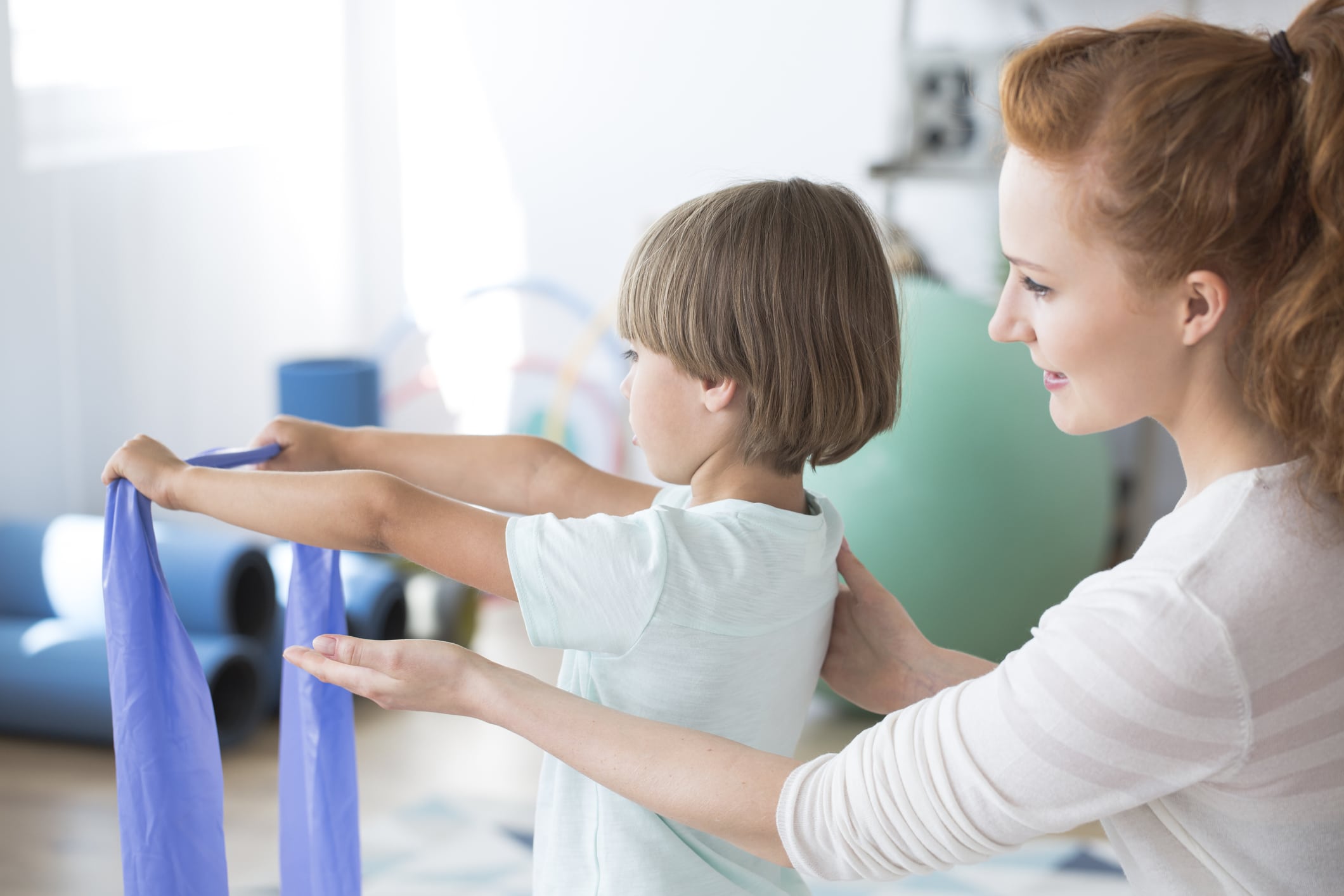Pediatric physical therapist helping a child with activities during early intervention physical therapy