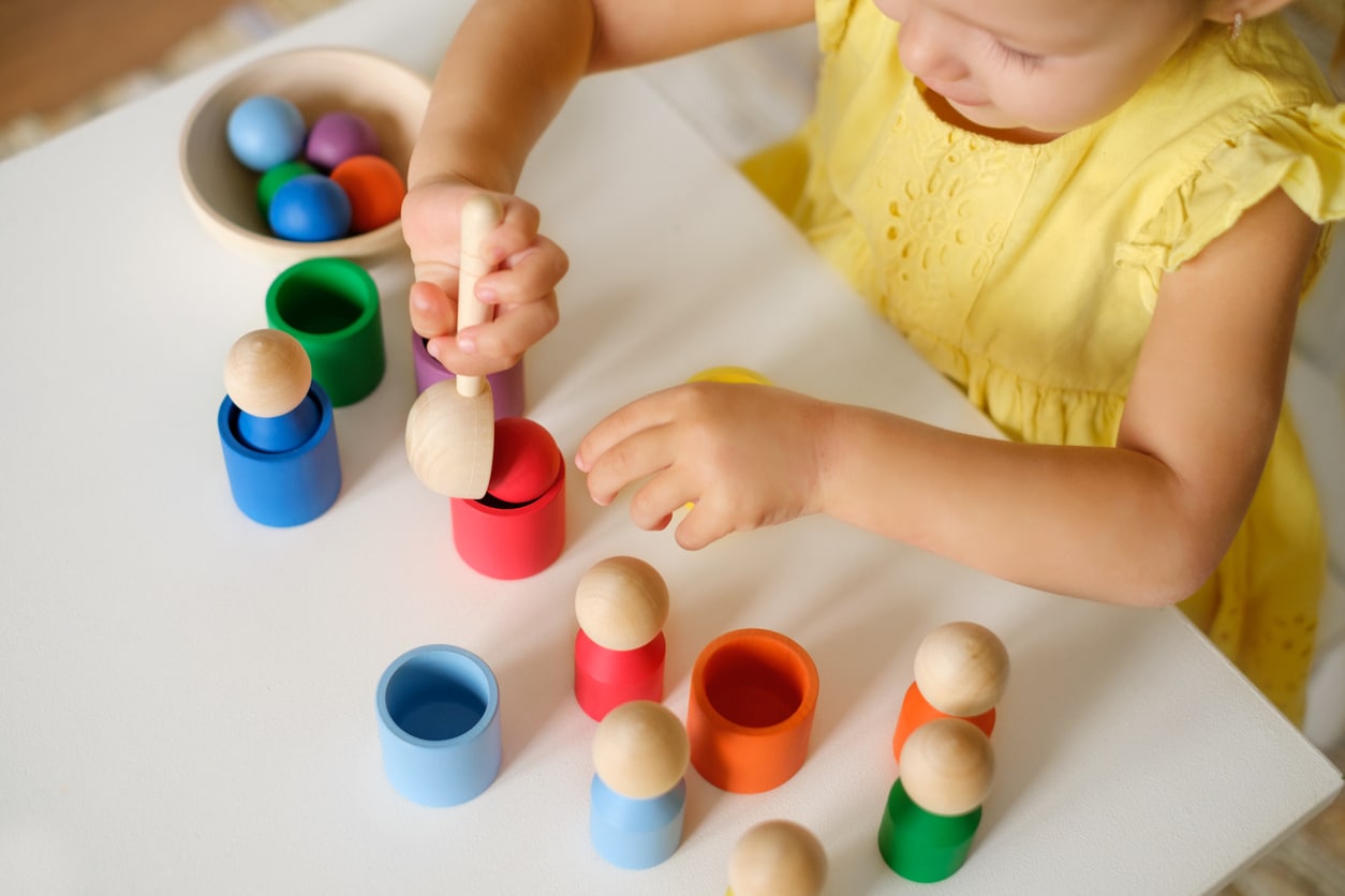 Young girl working on her fine motor skills at a table