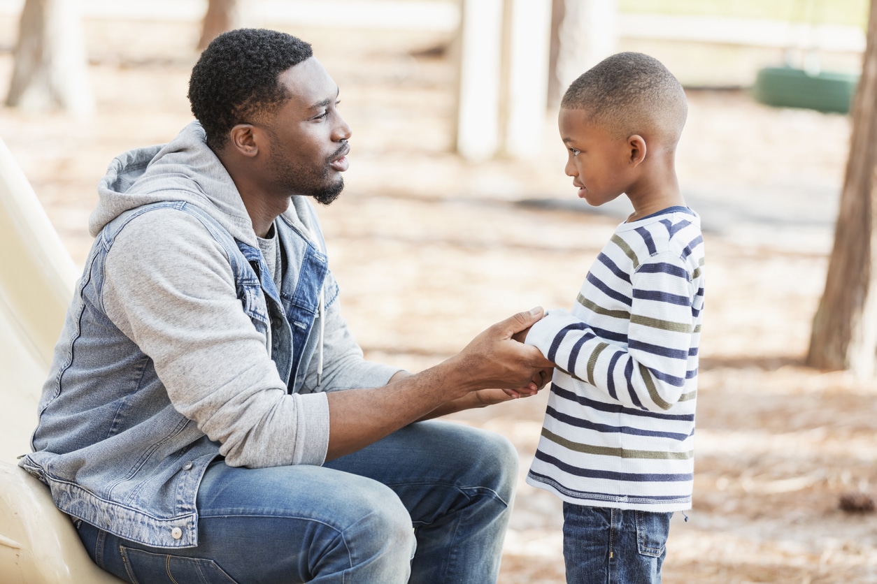 father talking to son with a pediatric voice disorder